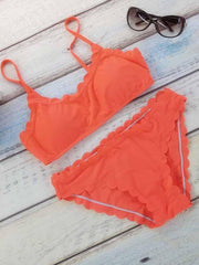 Orangefarbenes Bikinioberteil und -unterteil mit Muschelsaum